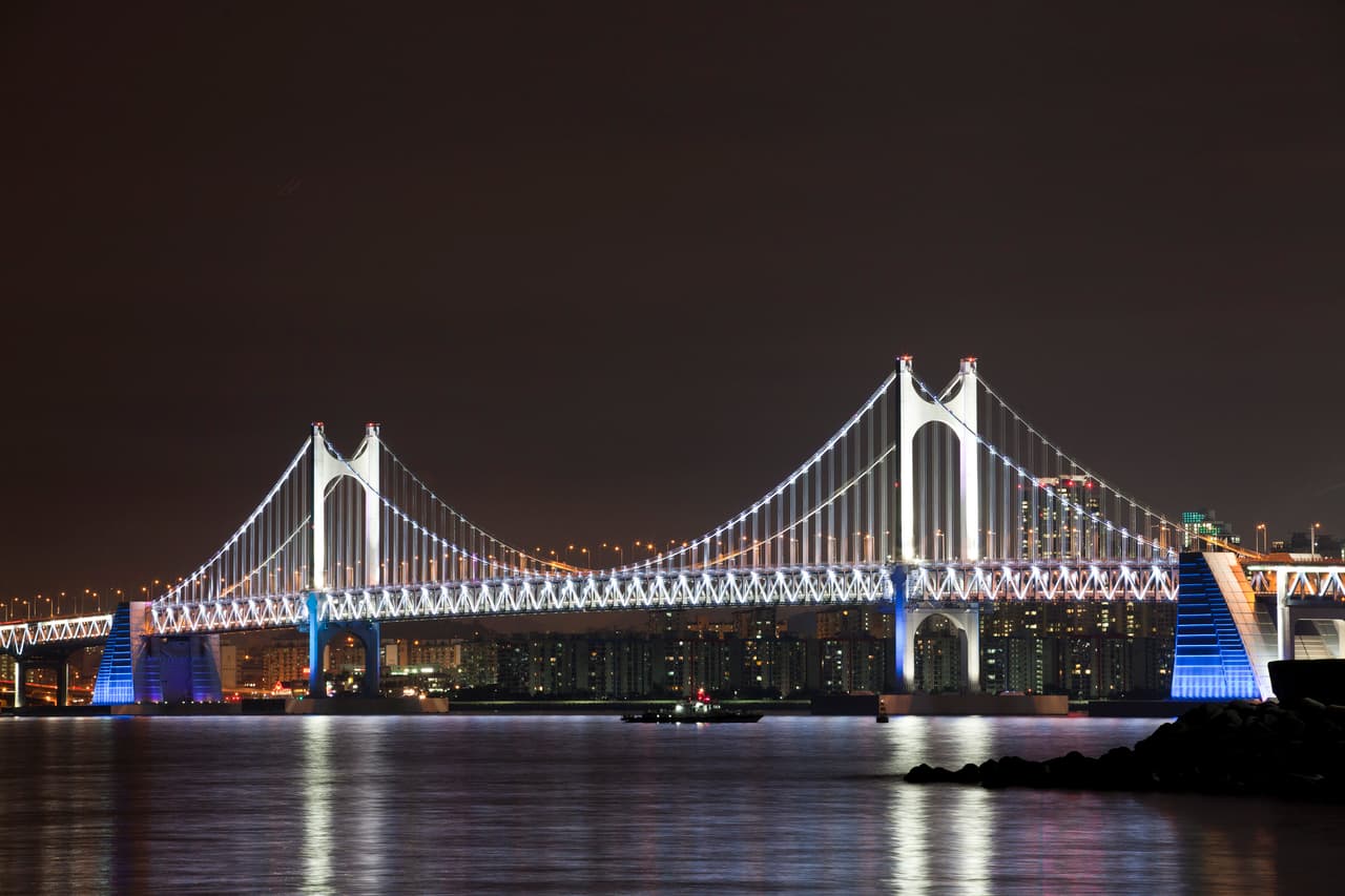The Gwangan Bridge lit up at night across the bay in Busan