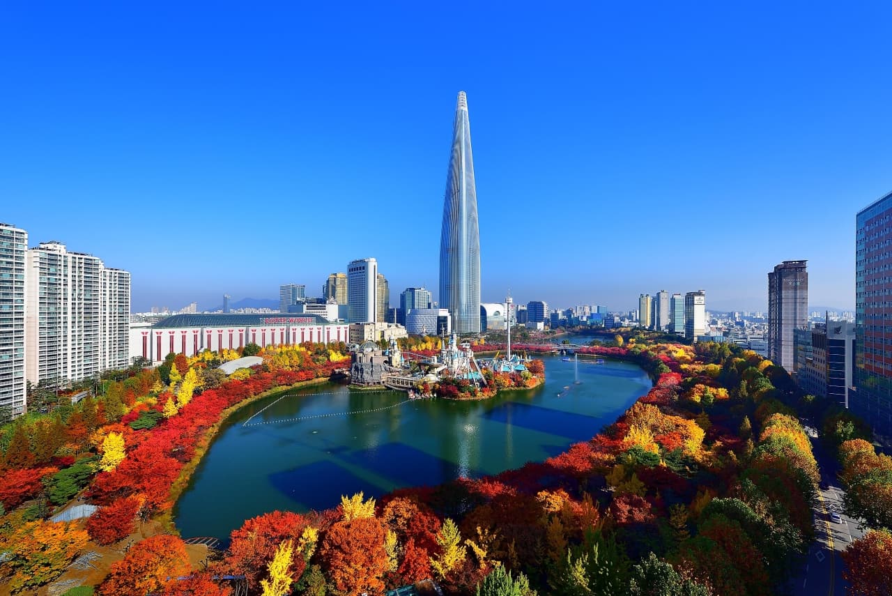 Seokchon Lake in autumn with Lotte World Tower and the city skyline behind, Seoul