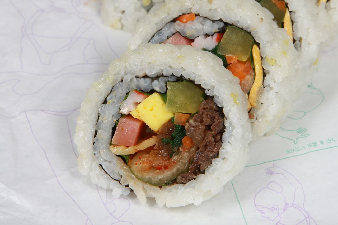 A close-up of sliced gimbap, Korean rice-and-seaweed rolls with assorted fillings