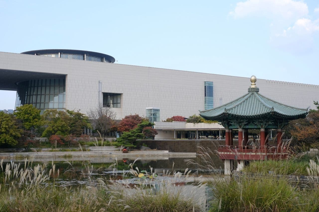 The National Museum of Korea building beyond its garden pond and a green-roofed pavilion