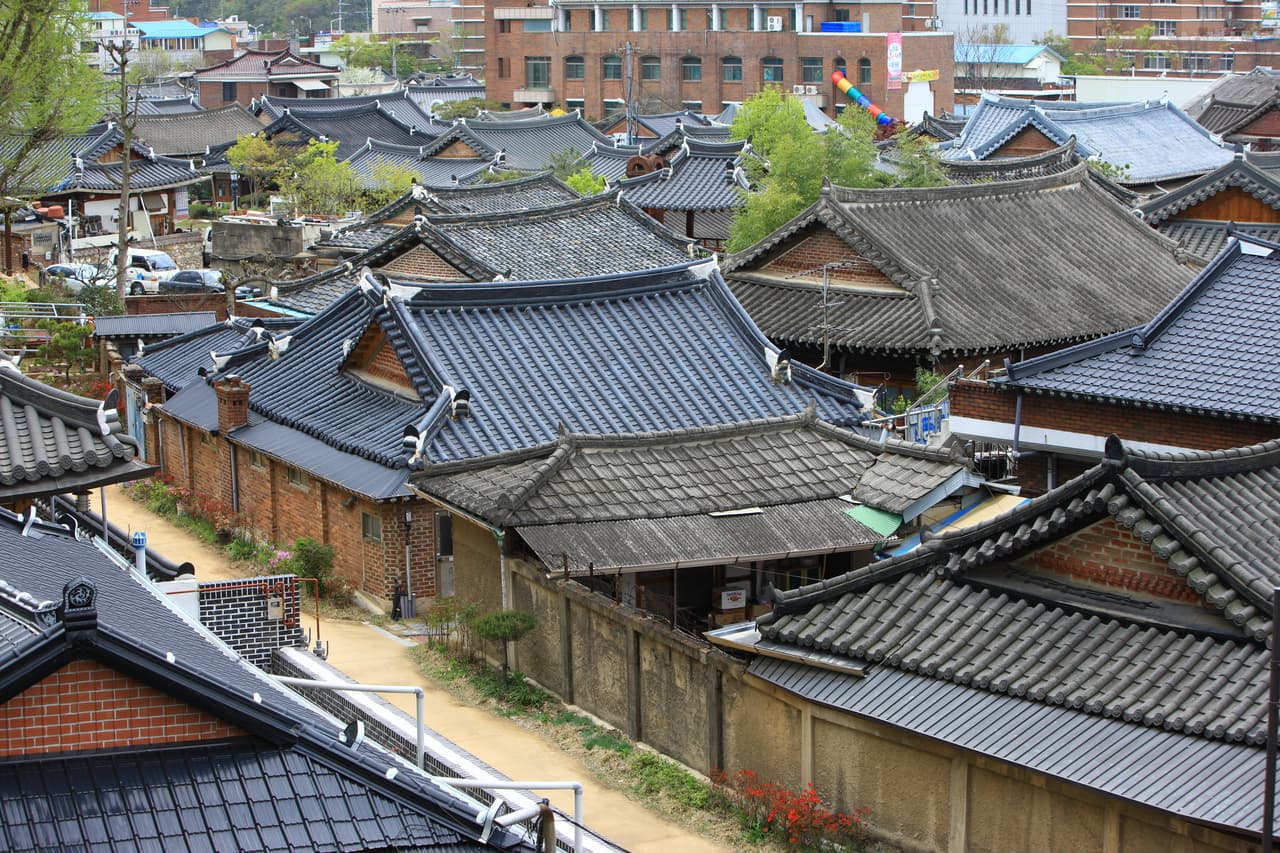 Tiled hanok rooftops and a brick-walled lane in Jeonju Hanok Village