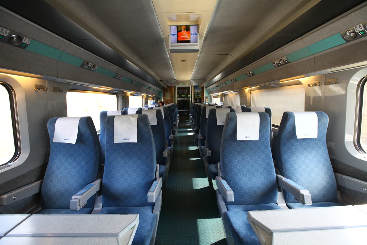 The empty standard-class cabin of a KTX high-speed train, with rows of reserved seats