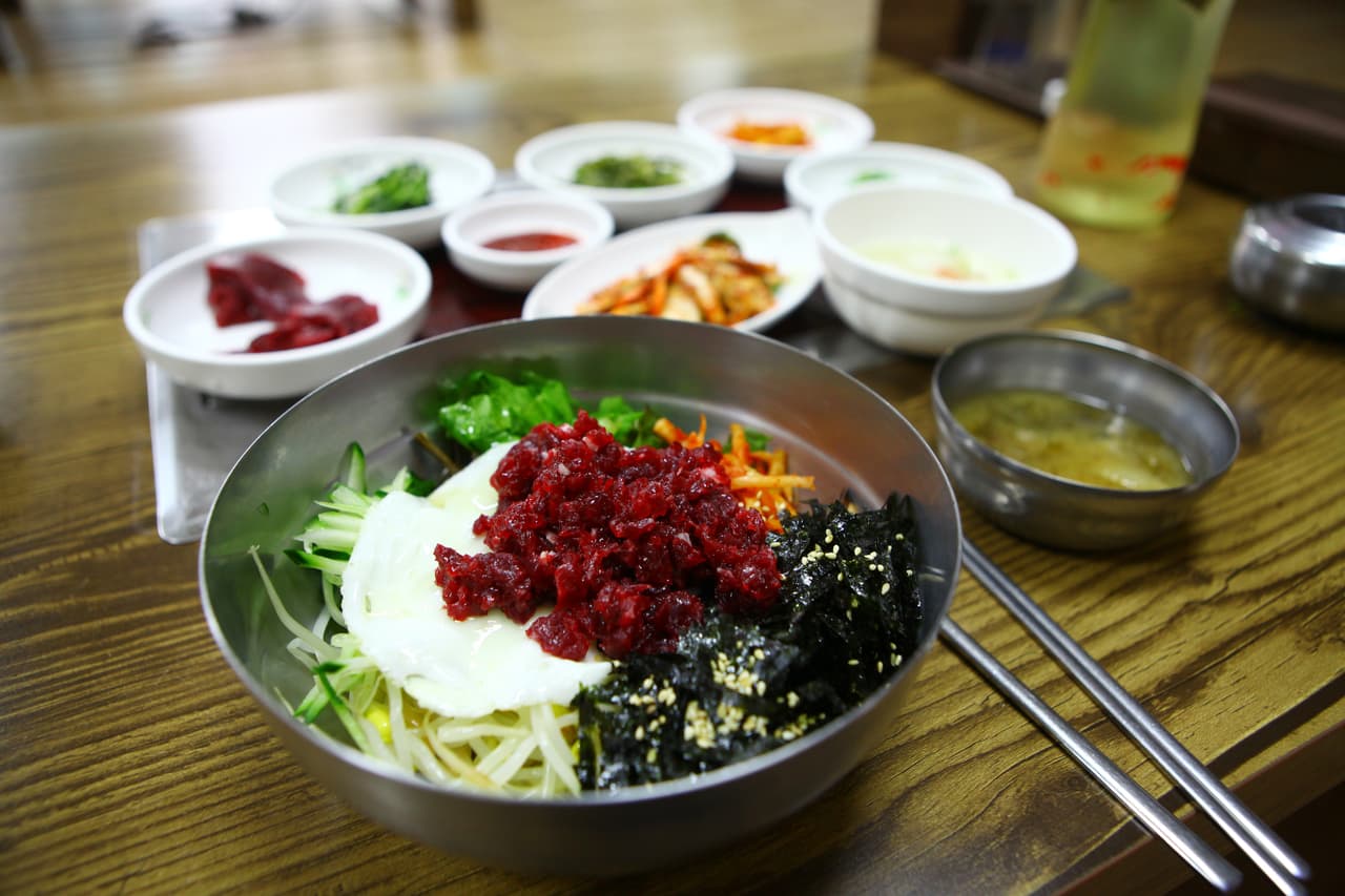Yukhoe bibimbap — a rice bowl topped with raw seasoned beef, vegetables, and an egg