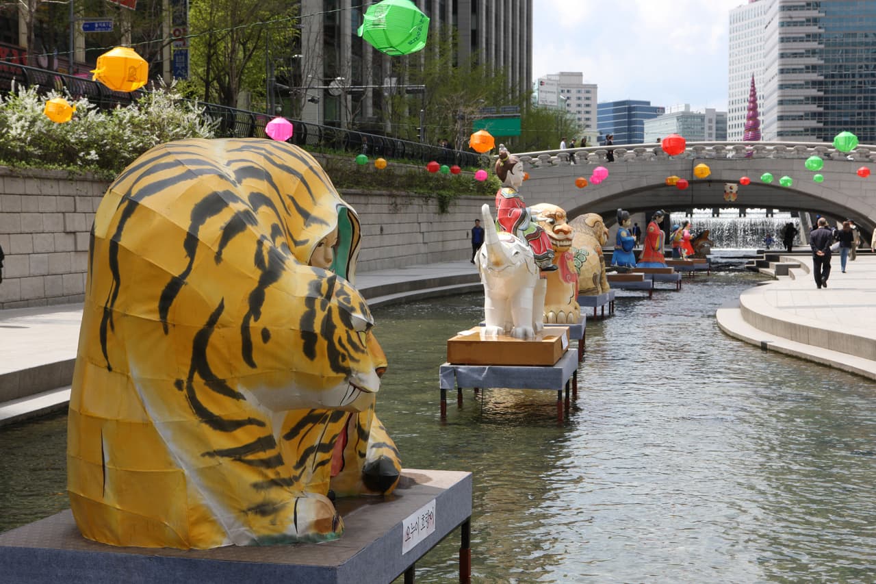 The Cheonggyecheon stream and a low bridge running between buildings in central Seoul