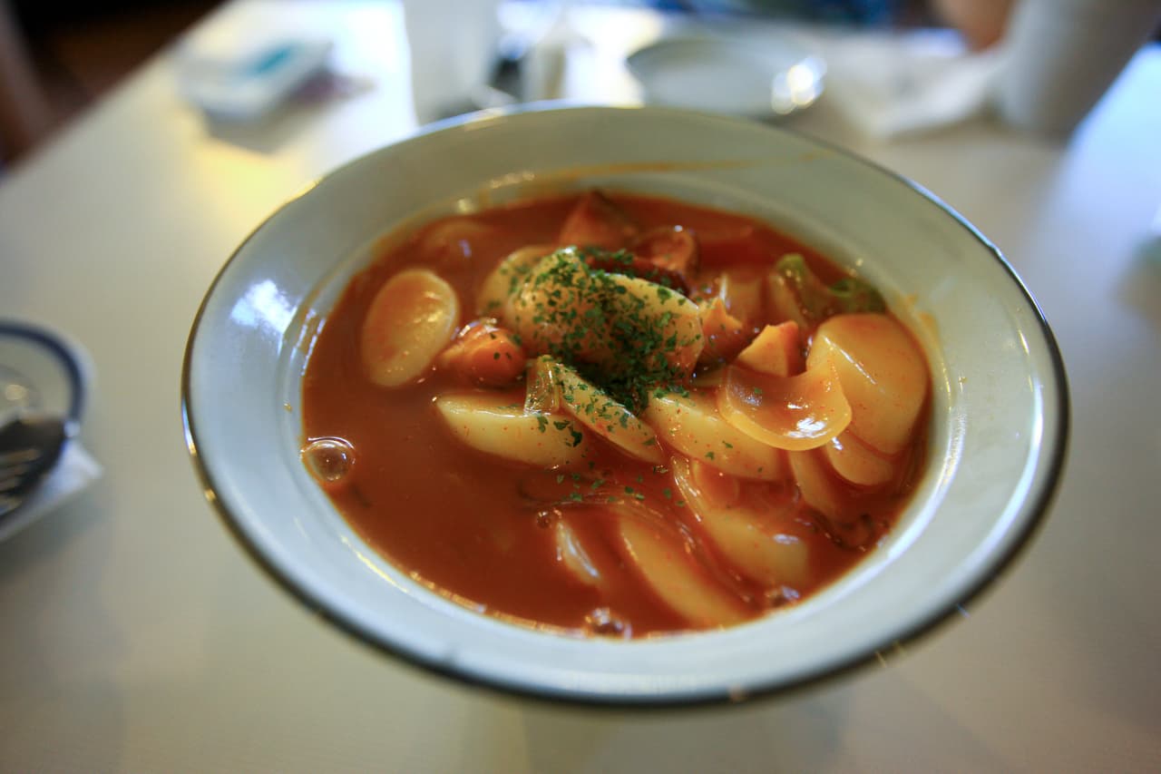 A bowl of tteokbokki, spicy Korean rice cakes in a red sauce