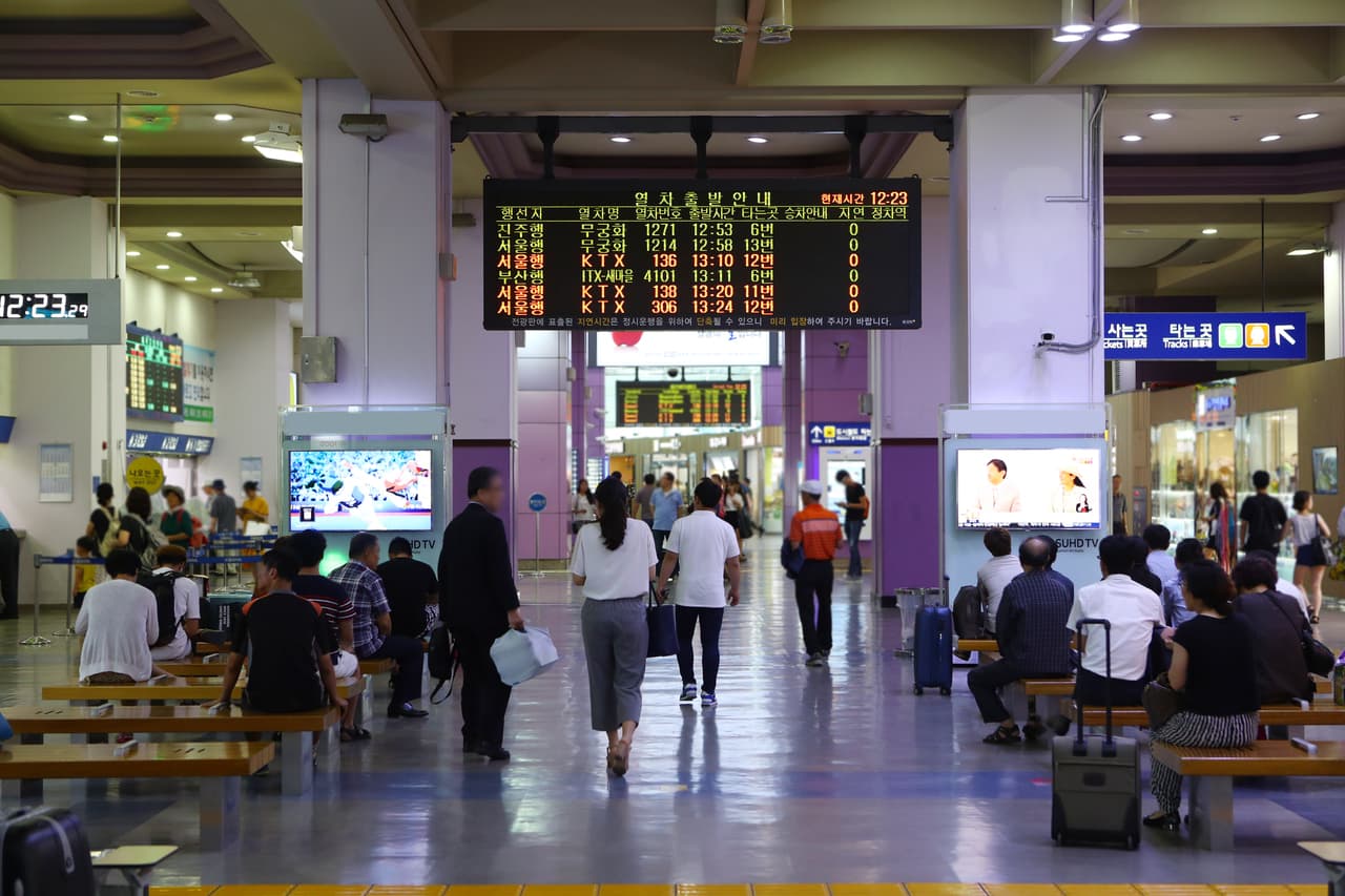 A station departure board listing KTX, ITX-Saemaeul, and Mugunghwa trains and destinations