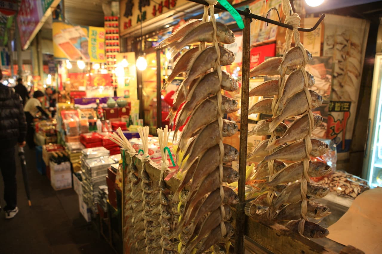 Busy market stalls displaying dried goods and packaged food at Gwangjang Market, Seoul