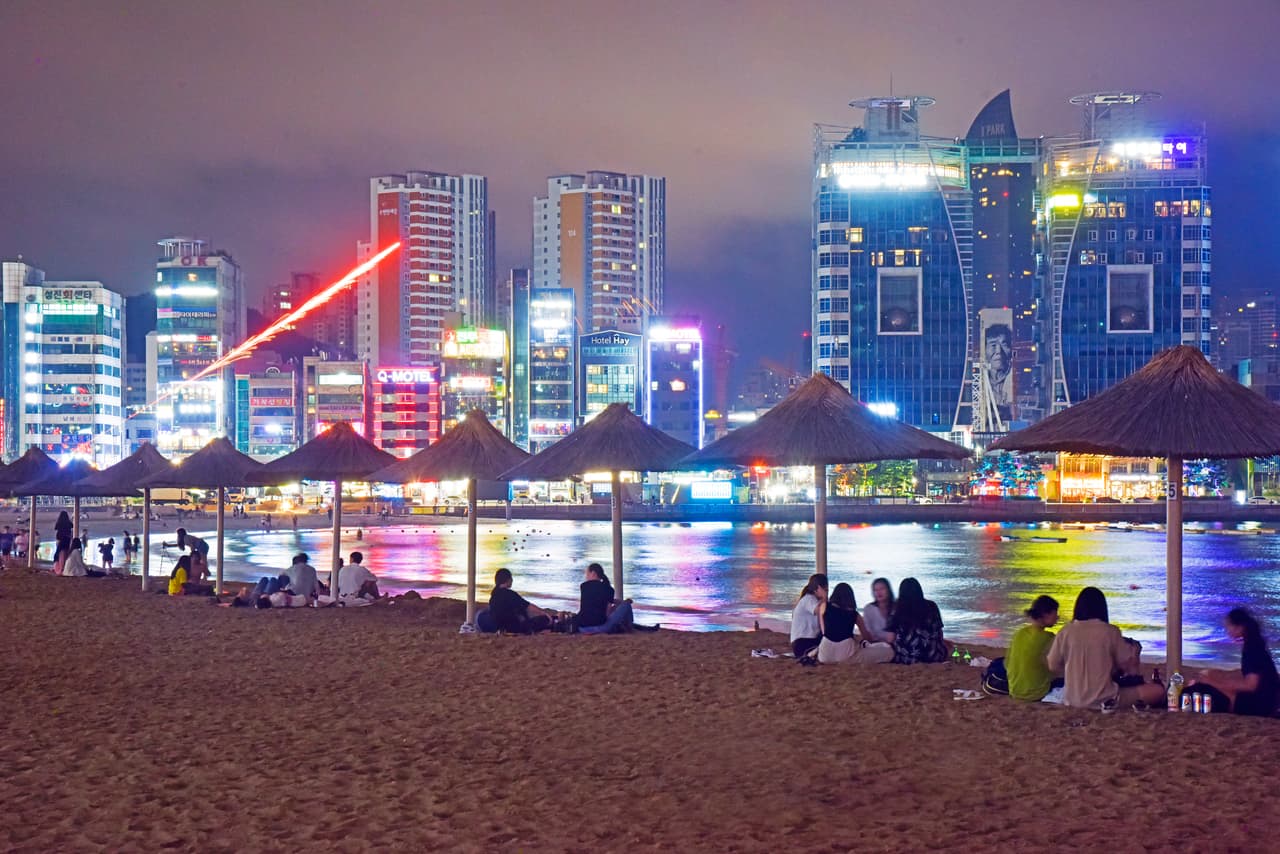 Gwangalli Beach in Busan at night, with the lit city skyline across the bay