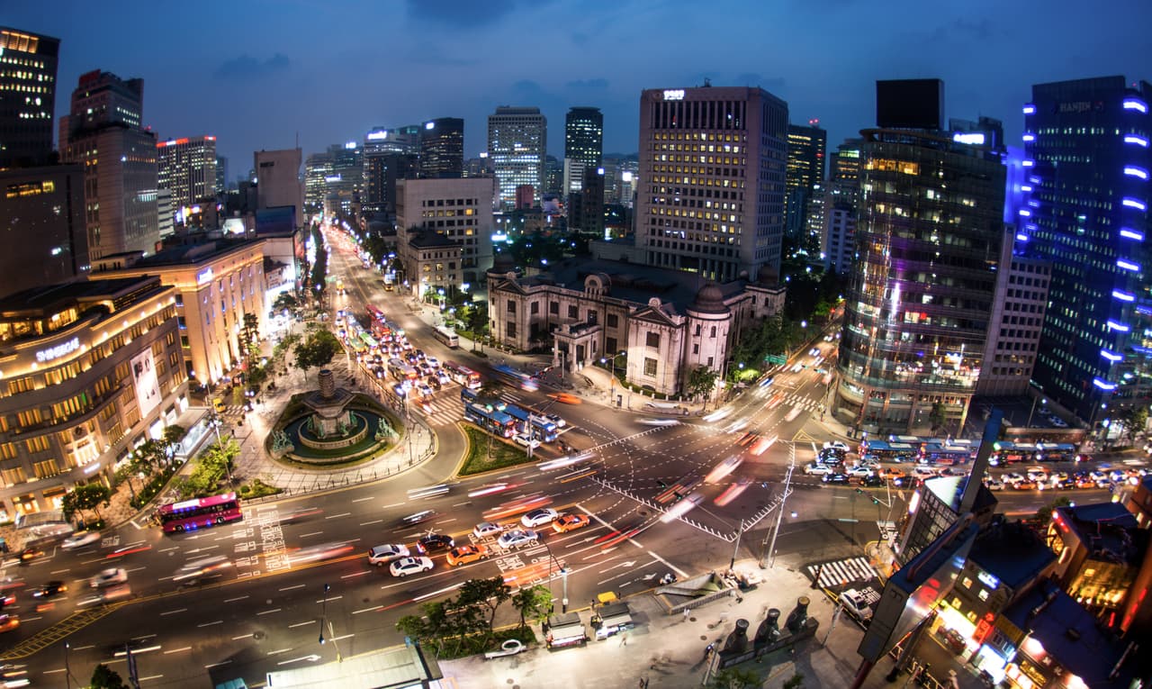 Night view over central Seoul near Myeongdong, with the historic Bank of Korea building lit up at the intersection