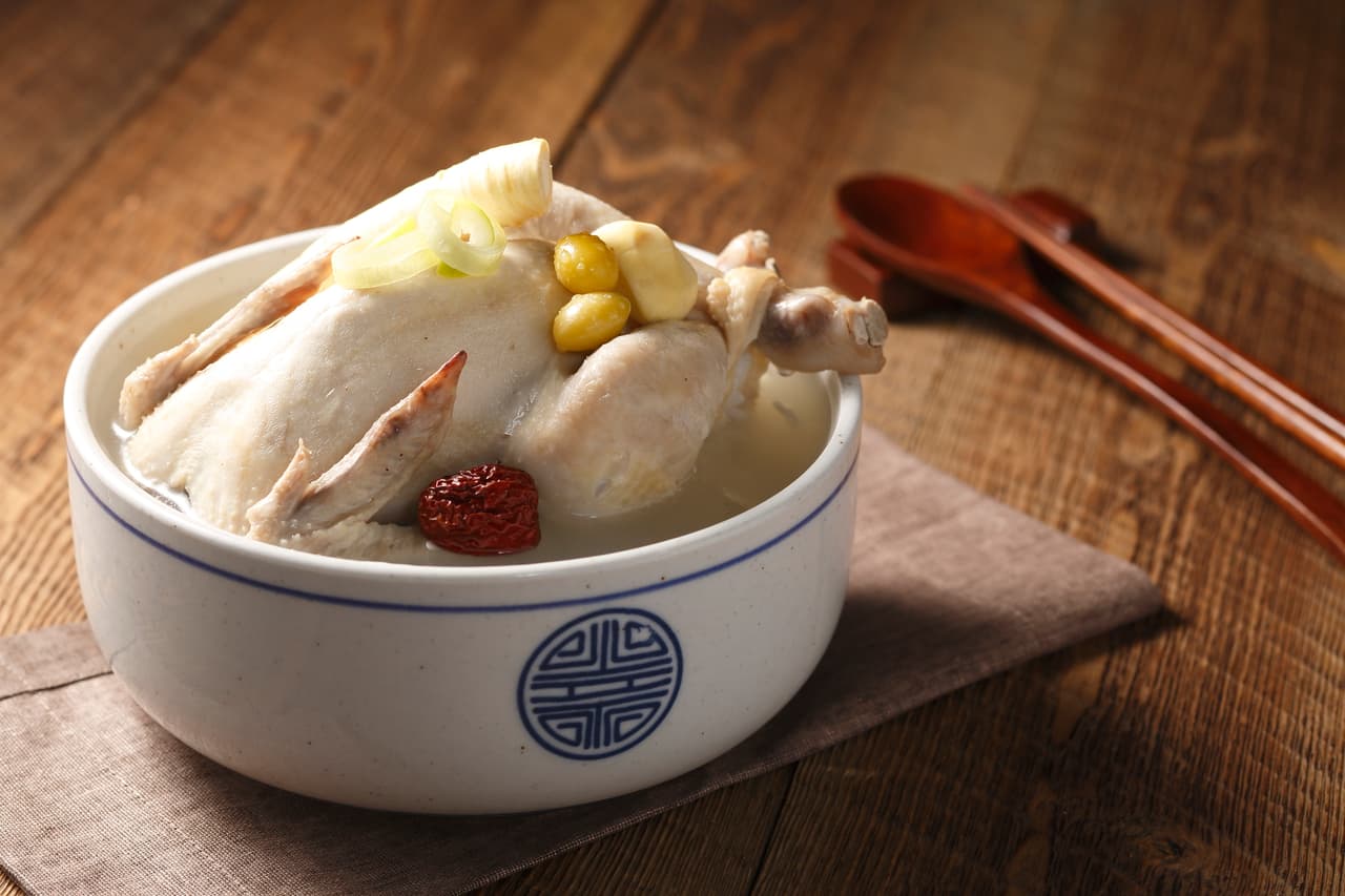 Korean samgyetang ginseng chicken soup served whole in a white stone bowl