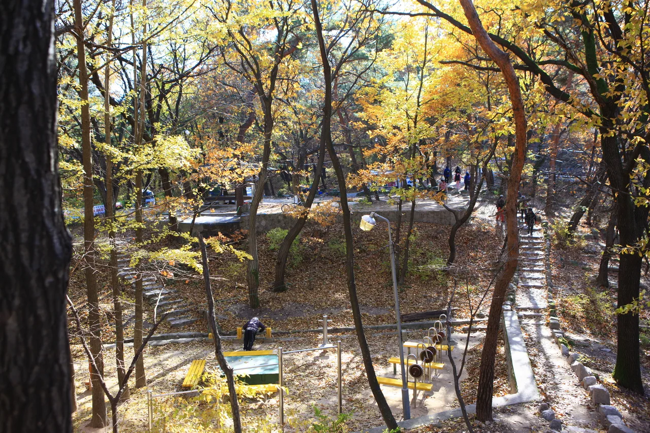 Hikers on a rocky ridge trail among Bukhansan granite outcrops in autumn