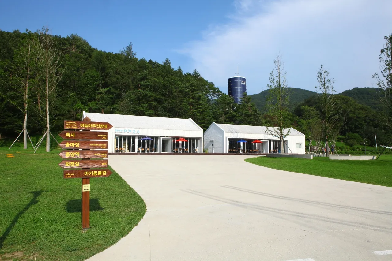 Wooden ranch buildings and a cafe terrace beside grassland at Daegwallyeong Sky Ranch