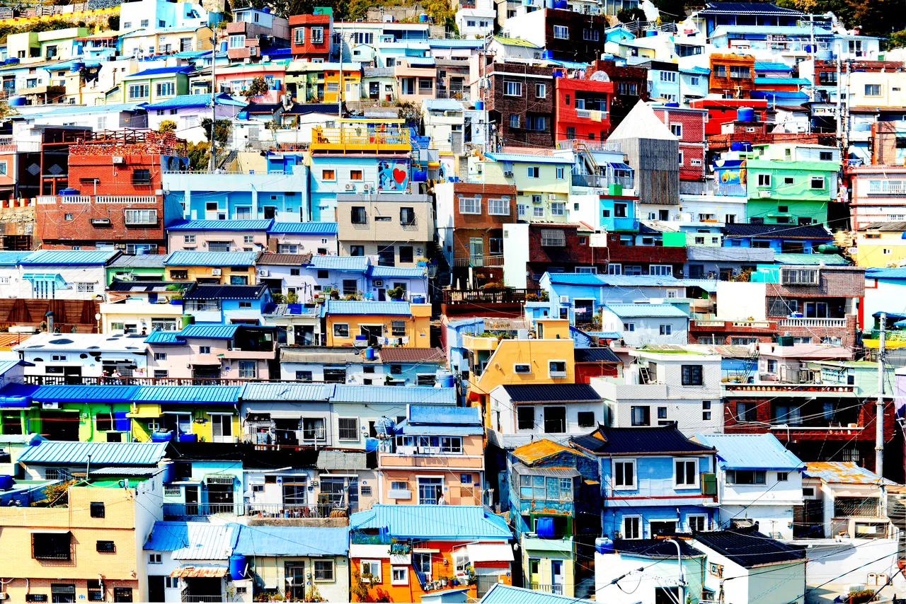 A close view of densely packed painted rooftops and house walls on a steep slope