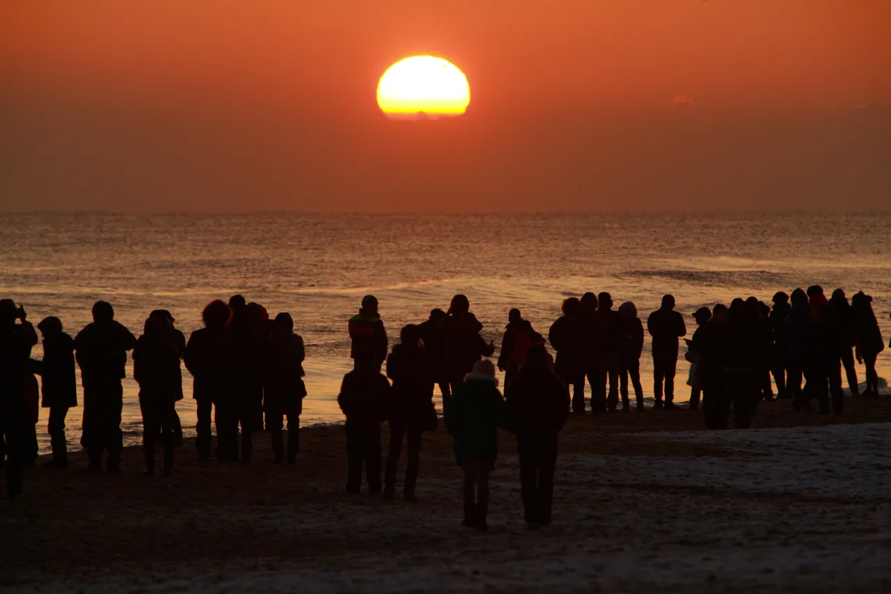 Sunrise over the sea at Gyeongpo Beach in Gangneung, with onlookers seen only as silhouettes