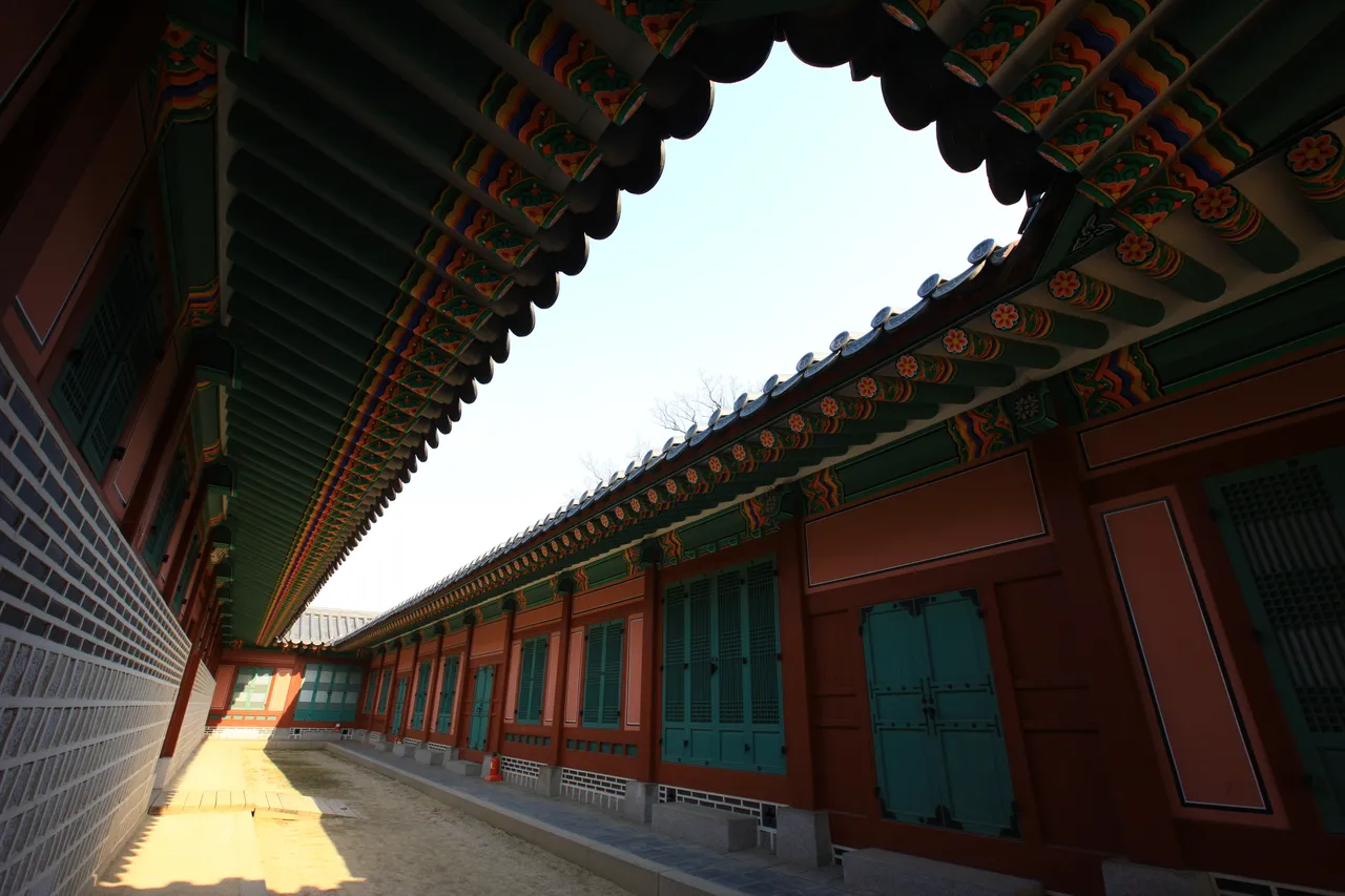 Gyeongbokgung Palace roofs and green trees under a clear blue sky in Seoul