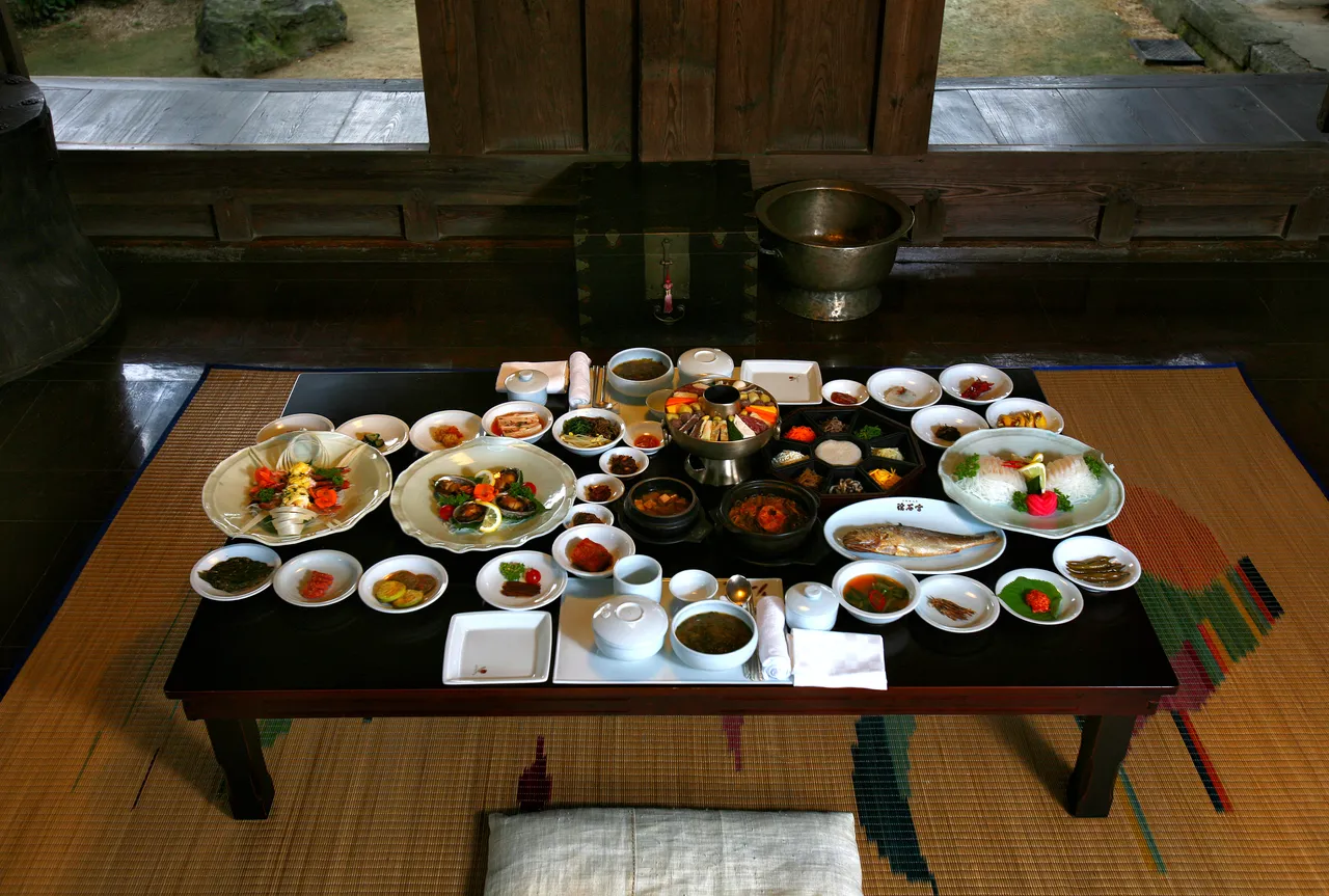 A traditional Korean multi-course meal laid out on a low table in a hanok room