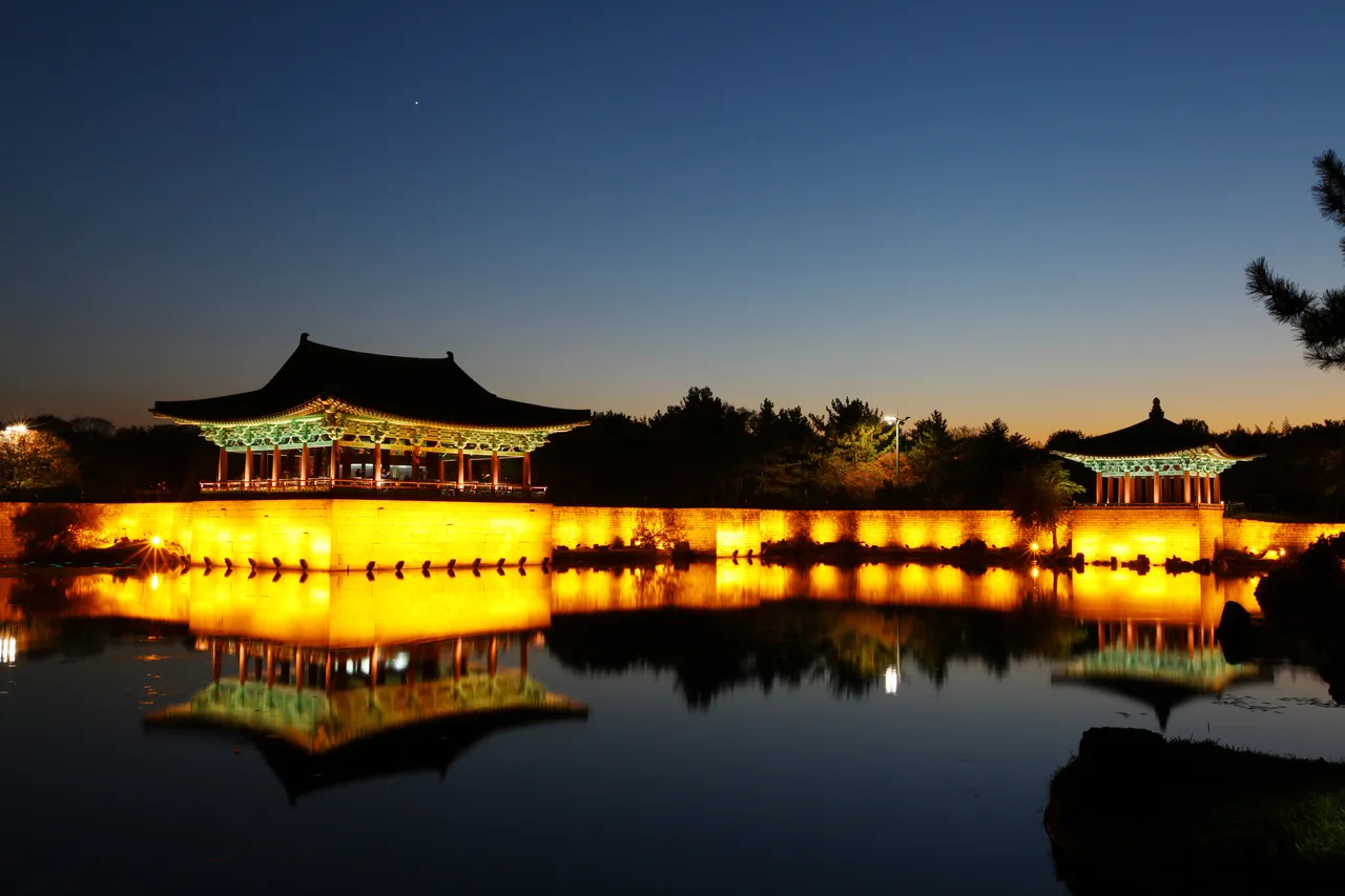 The illuminated pavilions of Donggung and Wolji pond reflected in the water at dusk, Gyeongju