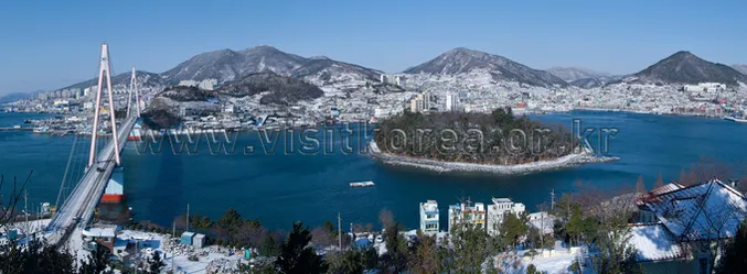 Visitors at a Dolsan Park overlook looking toward Yeosu harbor and Dolsan Bridge